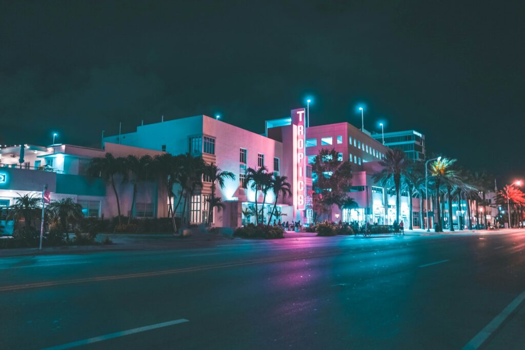 Calle de South Beach de noche con neón Art Deco y palmeras, Miami