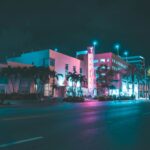 Calle de South Beach de noche con neón Art Deco y palmeras, Miami