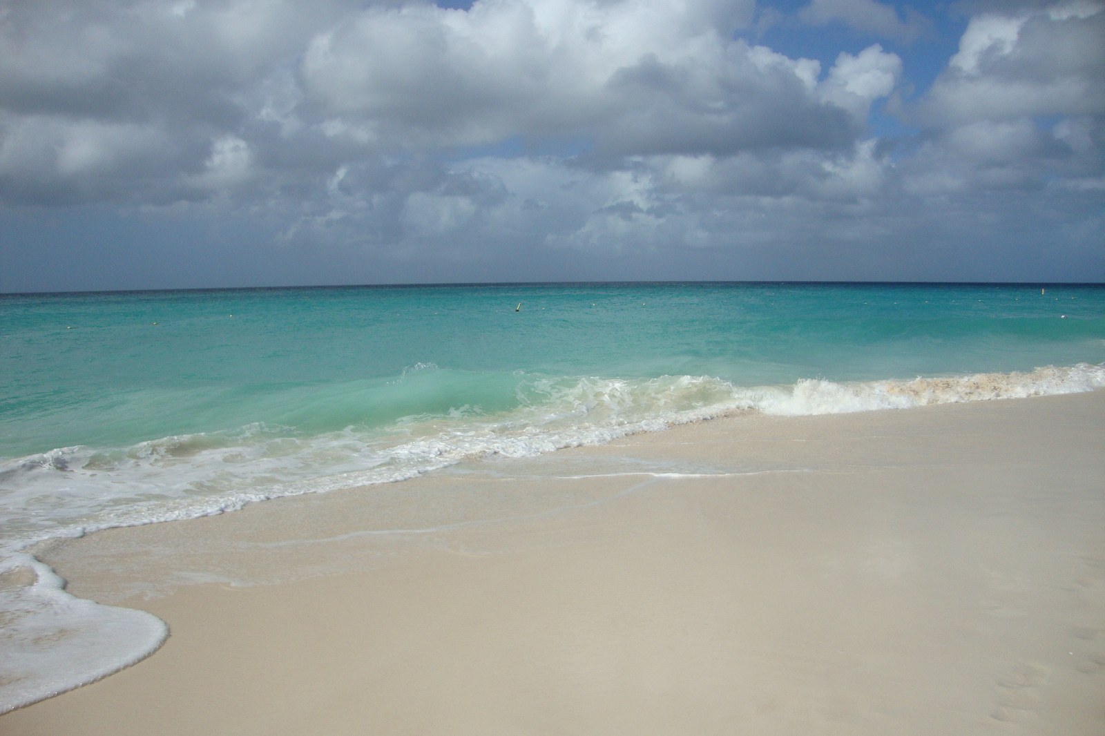 Eagle Beach en Aruba con arena clara, mar turquesa y horizonte bajo cielo azul