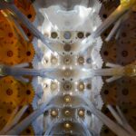 Barcelona desde Perú: techo de la Sagrada Família con bóvedas blancas, columnas ramificadas y luz amarilla