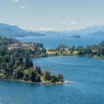 Bariloche desde Perú: península de Llao Llao cubierta de bosque entre lagos azules, con un gran hotel de techos rojos y montañas al fondo