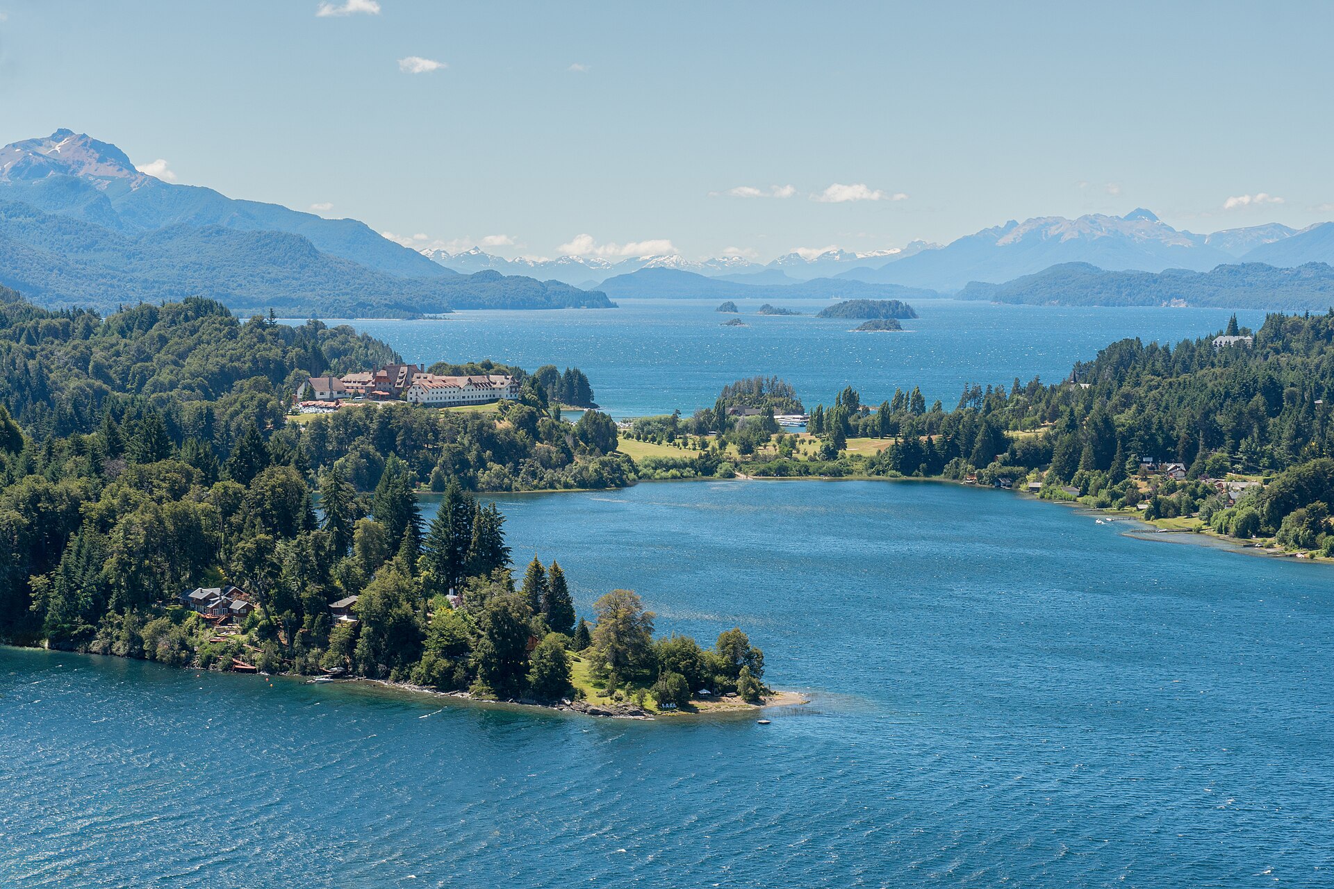 Bariloche desde Perú: península de Llao Llao cubierta de bosque entre lagos azules, con un gran hotel de techos rojos y montañas al fondo