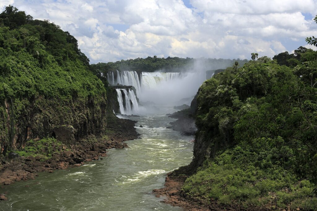 Cataratas del Iguazú: la Garganta del Diablo cae al fondo envuelta en bruma blanca, entre acantilados cubiertos de selva verde y un río de aguas verdosas