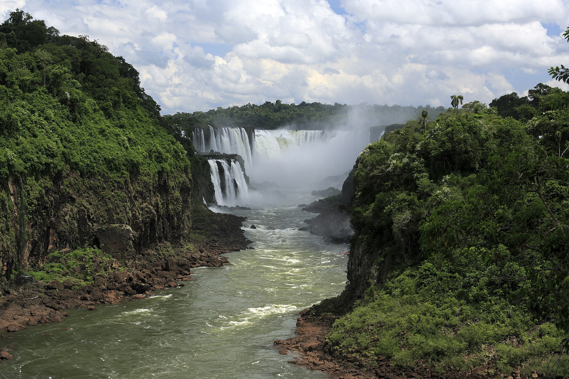Cataratas del Iguazú: la Garganta del Diablo cae al fondo envuelta en bruma blanca, entre acantilados cubiertos de selva verde y un río de aguas verdosas