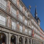 Madrid desde Perú: Casa de la Panadería en la Plaza Mayor, con frescos, balcones de hierro, torre con chapitel y banderas bajo cielo azul