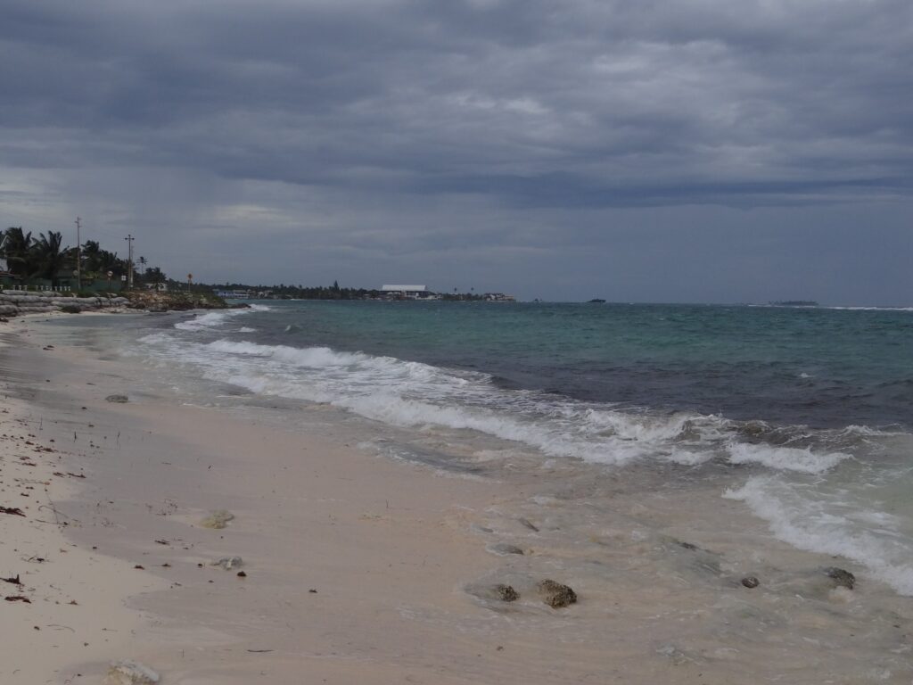 Playa de San Luis en San Andrés, Colombia, con arena clara, mar turquesa y vegetación al fondo
