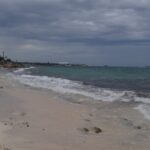 Playa de San Luis en San Andrés, Colombia, con arena clara, mar turquesa y cielo nublado