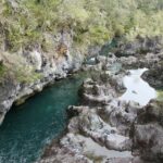 Parque Nacional Vicente Pérez Rosales: río de agua verde que corre entre grandes rocas grises en los Saltos del Petrohué, rodeado de arbustos y árboles